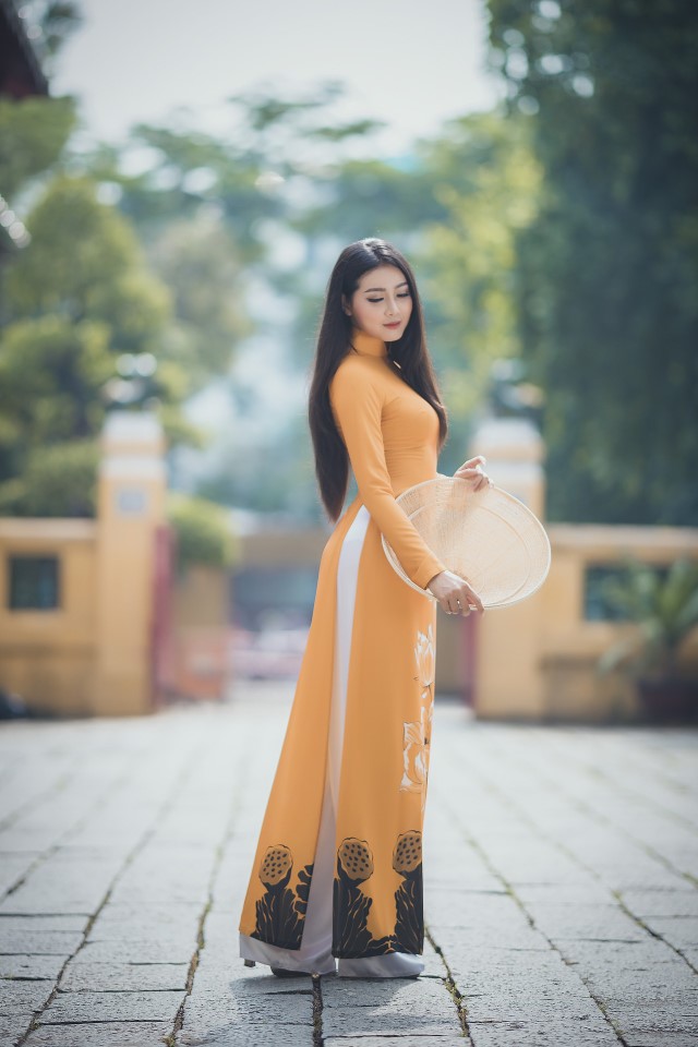 黄色い系のアオザイを着たベトナム人女性